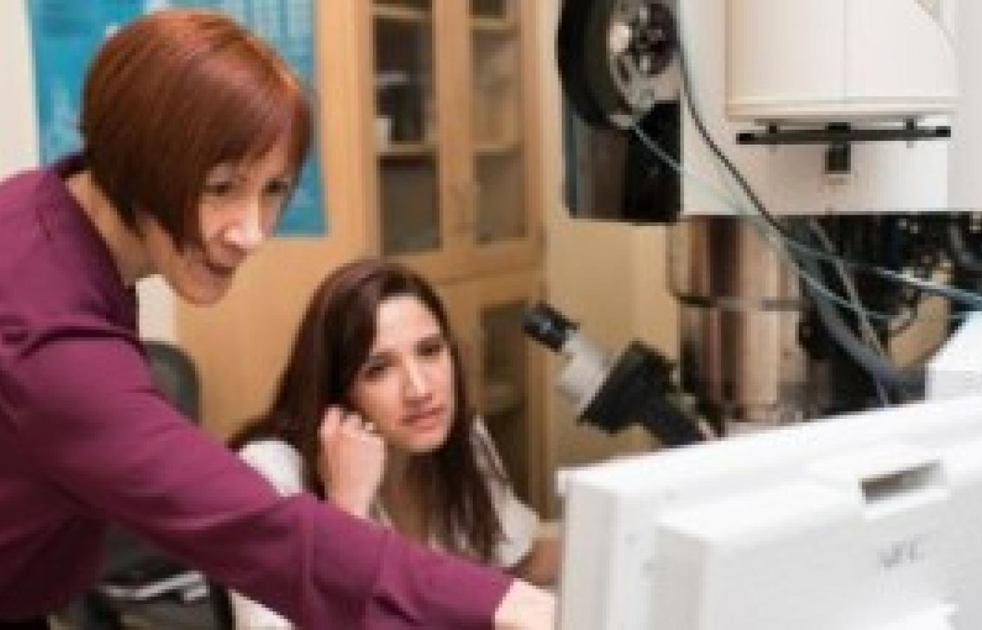Melissa Santala works with student, points at computer screen